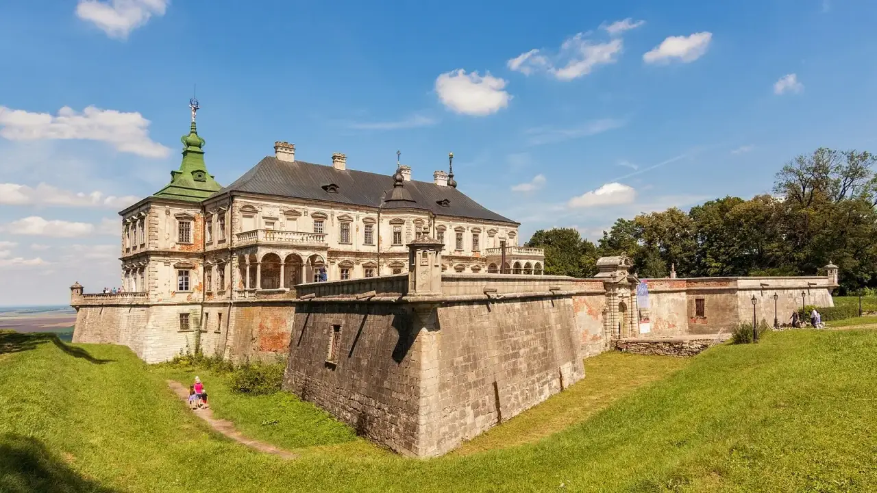 Високі скелі колишньої фортеці Тустань серед зеленого лісу на Львівщині